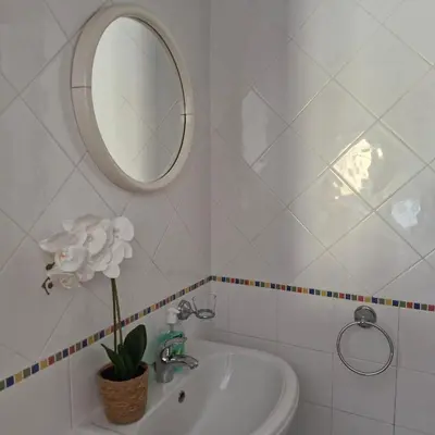 a white bathroom with a sink and a mirror at Moradia V2 - 200m da Praia da Oura - Santa Eulália in Albufeira