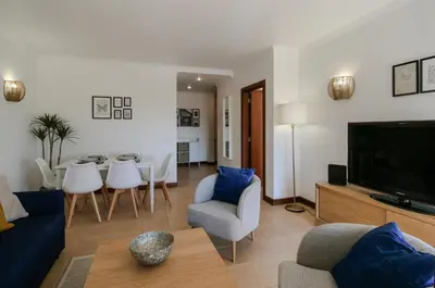 a living room with a couch and a dining room at FLH Salgados Balcony Flat in Albufeira