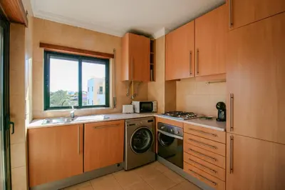 a kitchen with a sink and a washing machine at FLH Salgados Balcony Flat in Albufeira