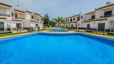 a large blue swimming pool in front of some buildings at Charming 3-Bedroom Villa with Pool in Albufeira in Albufeira