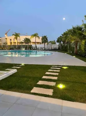a large swimming pool with lights in the grass at Lakes 24 - Av Praia da Falésia in Quarteira