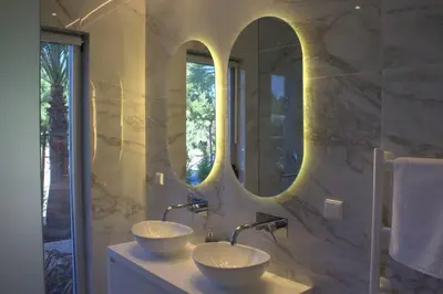 a bathroom with two sinks and two mirrors at Lakes 24 - Av Praia da Falésia in Quarteira