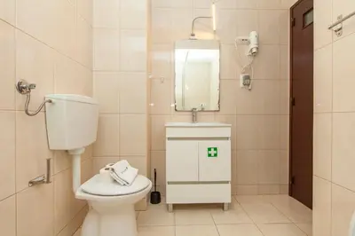 a bathroom with a toilet and a sink and a mirror at Seacliff Albufeira in Albufeira