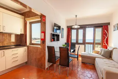 a kitchen and living room with a couch and a table at Seacliff Albufeira in Albufeira