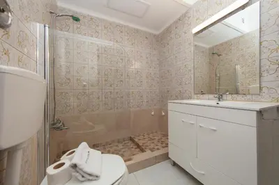 a bathroom with a toilet and a sink and a shower at Seacliff Albufeira in Albufeira