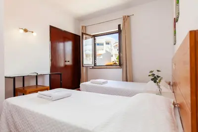 two beds in a room with a window at Seacliff Albufeira in Albufeira
