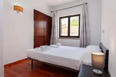a bedroom with a white bed and a window at Seacliff Albufeira in Albufeira
