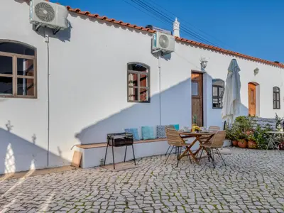 a patio with a table and chairs in front of a house at Holiday Home Rocha by Interhome in Albufeira