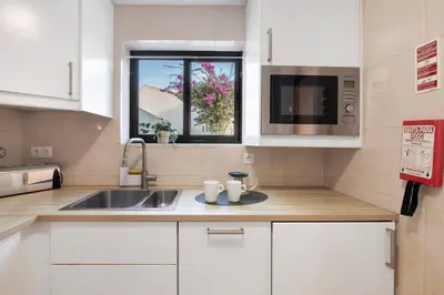 a kitchen with white cabinets and a sink and a window at Cool Motion 2149 in Albufeira