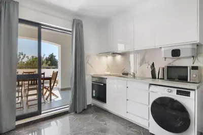 a white kitchen with a washer and dryer in it at Magnificent Beach Apartment in Albufeira