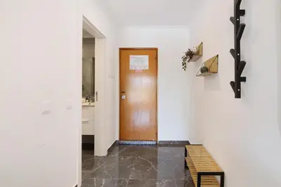 a hallway with a wooden door and a bench at Magnificent Beach Apartment in Albufeira