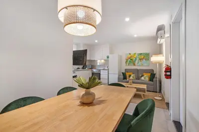 a dining room table with green chairs and a vase on it at Stunning Modern Apartment In Oura in Albufeira