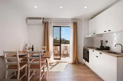 a balcony with two chairs and a table and a television at Lovely And New Apartment In Oura in Albufeira