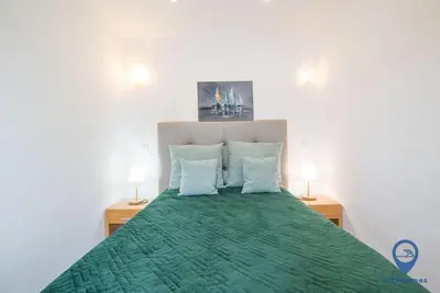a bedroom with a green bed with two lamps at Garrett by MTPhomes in Albufeira
