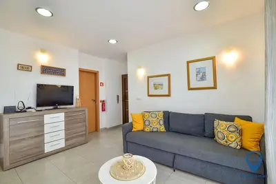 a living room with a blue couch and a flat screen tv at Garrett by MTPhomes in Albufeira
