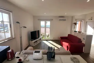 a living room with a red couch and a tv at Sea View Apartment Faro in Faro