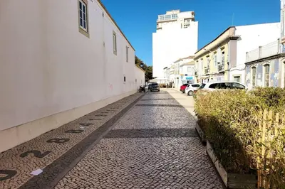 a cobblestone street next to a white building at Sea View Apartment Faro in Faro