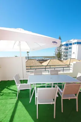 a table and chairs and an umbrella on a patio at Marimar Sea View Apartment Faro in Faro