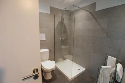 a bathroom with a toilet and a glass shower at Marimar Sea View Apartment Faro in Faro