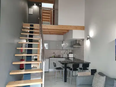 a kitchen and a staircase in a room with a table at Faro Ria Formosa Twin at city center in Faro