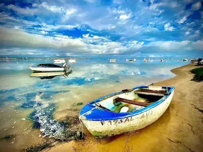 a boat sitting on the shore of a beach at Faro Ria Formosa Twin at city center in Faro