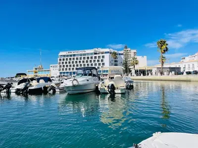 a group of boats are docked in the water at Faro Ria Formosa Twin at city center in Faro