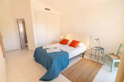 a bedroom with a bed and a table with towels on it at Vilamoura Beach Villa with Private Pool in Quarteira