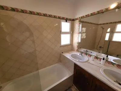 a bathroom with a tub and a sink and a mirror at Vilamoura Beach Villa with Private Pool in Quarteira