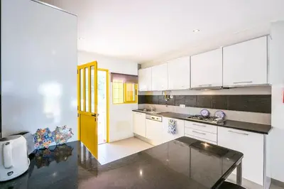 a kitchen with white cabinets and a yellow door at Vilamoura Beach Villa by nature with Olympic Pool in Quarteira