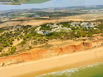 an aerial view of a beach with houses and trees at Vilamoura Beach Villa by nature with Olympic Pool in Quarteira