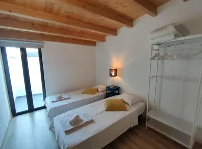 two beds in a room with a window at Typical house Faro downtown private entrance in Faro