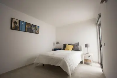 a white bedroom with a white bed and a window at Typical house Faro downtown private entrance in Faro