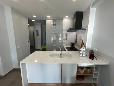 a white kitchen with a sink and a stove at Carteia Mar by FHR frente Mar & piscina in Quarteira