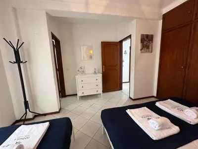 a bedroom with two beds and a dresser in it at Âncora by FHR a 600m da praia in Quarteira