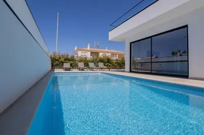 a swimming pool in the backyard of a house at Sirius House in Guia