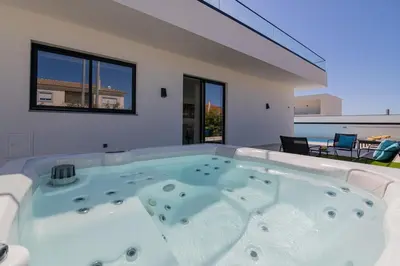 a large hot tub in a room with a patio at Sirius House in Guia