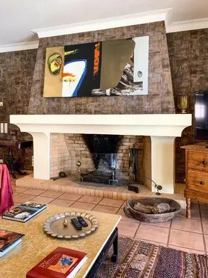 a living room with a fireplace and a table at Villa Monte dos Agostos by Boaz Rentals in Santa Bárbara de Nexe