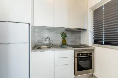 a kitchen with white cabinets and a sink at Pinhal da Praia by Garvetur in Quarteira