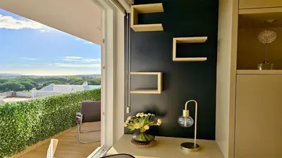 a room with a window with a table with flowers at MouraSuites CD 601 - Cleverdetails in Vilamoura