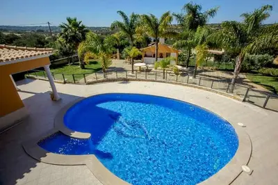 a large blue swimming pool in a yard at Quinta do Sol in Guia