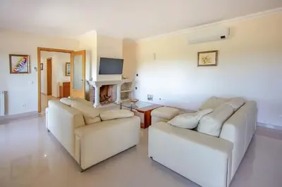 a living room with two white couches and a television at Quinta do Sol in Guia