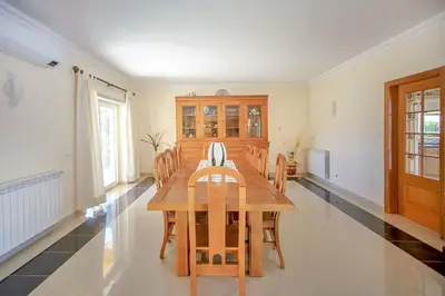 a dining room with a wooden table and chairs at Quinta do Sol in Guia