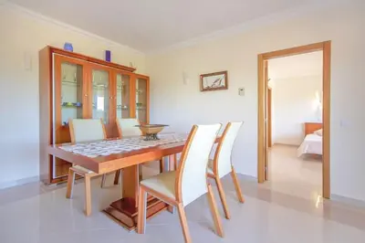 a dining room with a table and white chairs at Quinta do Sol in Guia