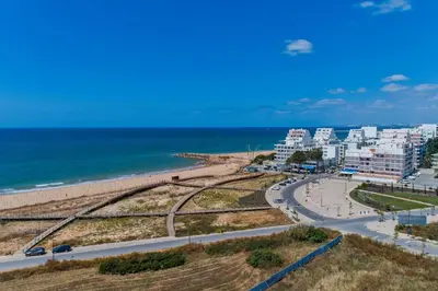 a view of a beach with buildings and the ocean at Sol e Mar in Quarteira