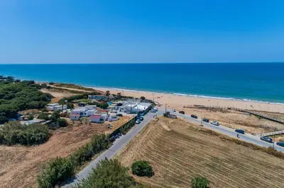 an aerial view of a beach with cars parked at Sol e Mar in Quarteira