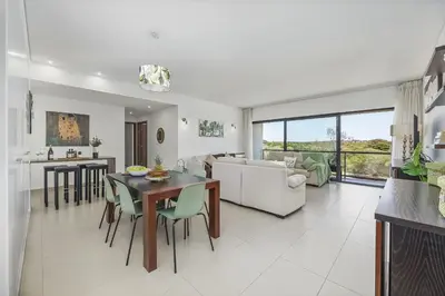 a kitchen and living room with a table and chairs at Vista Mar in Quarteira