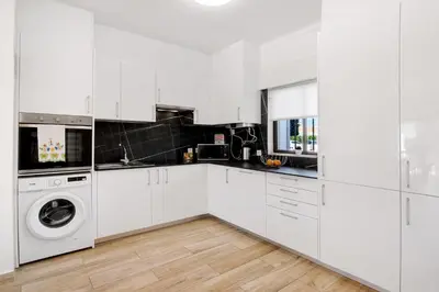 a white kitchen with a washer and dryer at Apartment Zeza in Albufeira