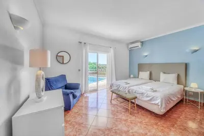 a bedroom with a bed and a blue wall at Villa Garbino in Albufeira