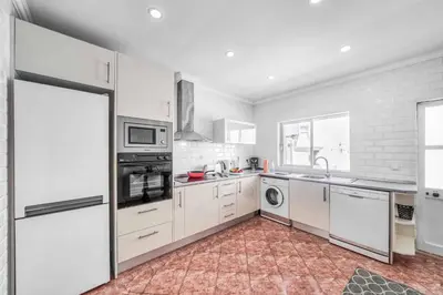 a kitchen with white cabinets and a washer and dryer at Villa Garbino in Albufeira