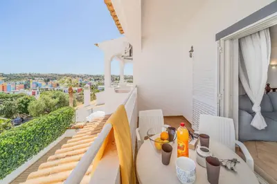 a dining room with a table and a balcony at Villa Alecrim in Albufeira
